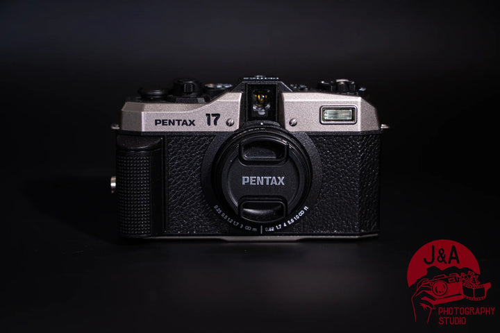 Pentax 17 35mm film camera with half-frame format, seven shooting modes, and zone-focus system, front side with lens cap