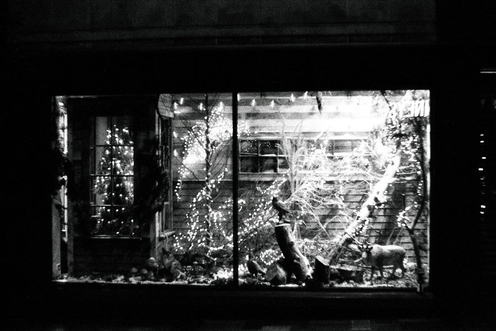 Night shot of a Christmas market captured on Ilford Delta 3200 35mm film, showing festive lights, fine grain, and deep contrast.