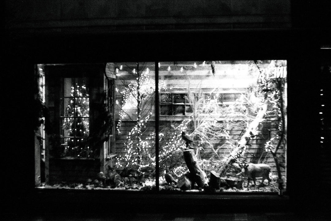 Night shot of a Christmas market captured on Ilford Delta 3200 35mm film, showing festive lights, fine grain, and deep contrast.