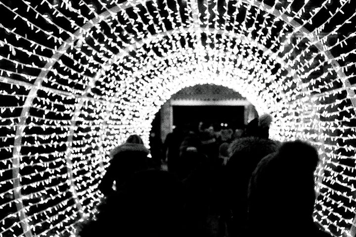 Crowd at a Christmas market photographed with Ilford Delta 3200 film, featuring bright stalls, rich shadows, and classic black and white tones.