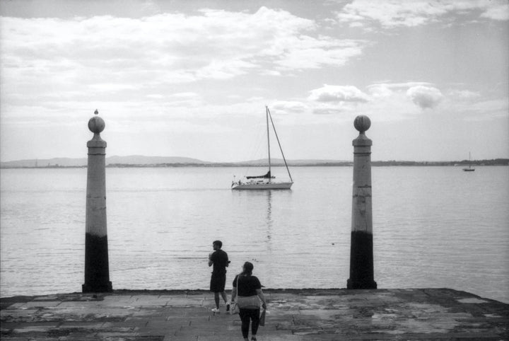 Boat at a pier photographed on Ilford FP4 Plus black and white film, highlighting fine grain, smooth tonal range, and detailed textures.