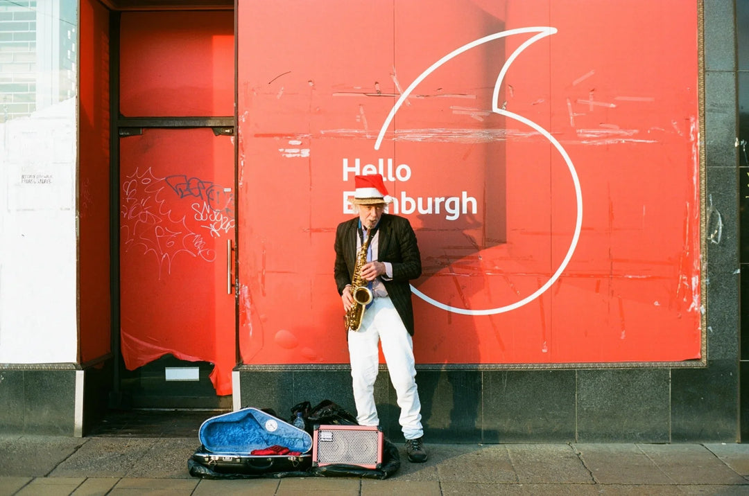 Street musician playing saxophone photographed on Kodak Ektar 100 film, capturing lively colours and crisp, professional-quality detail.