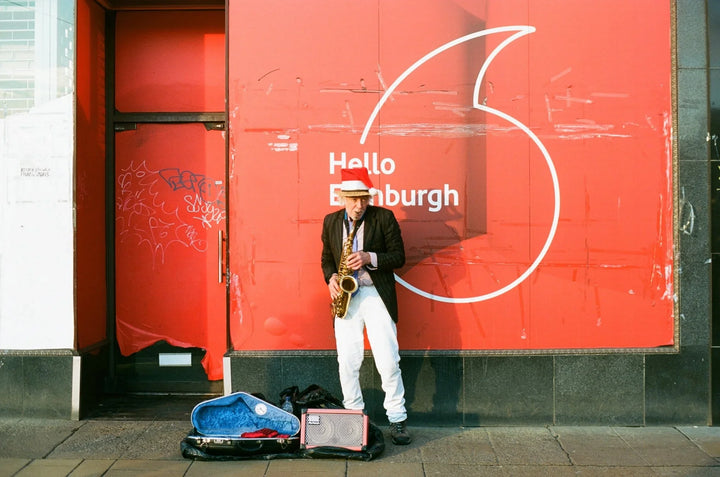 Street musician playing saxophone photographed on Kodak Ektar 100 film, capturing lively colours and crisp, professional-quality detail.