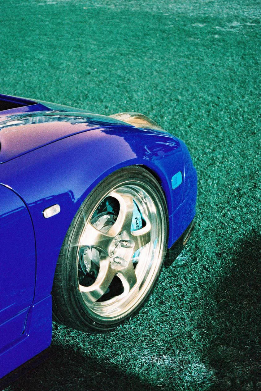 Classic car captured on Lomography Lomochrome Turquoise film showing vivid blue and copper tones with surreal color shifts.